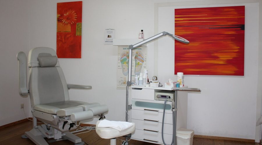 Behandlungsraum mit Podologiestuhl, Gerätewagen und Arbeitsleuchte